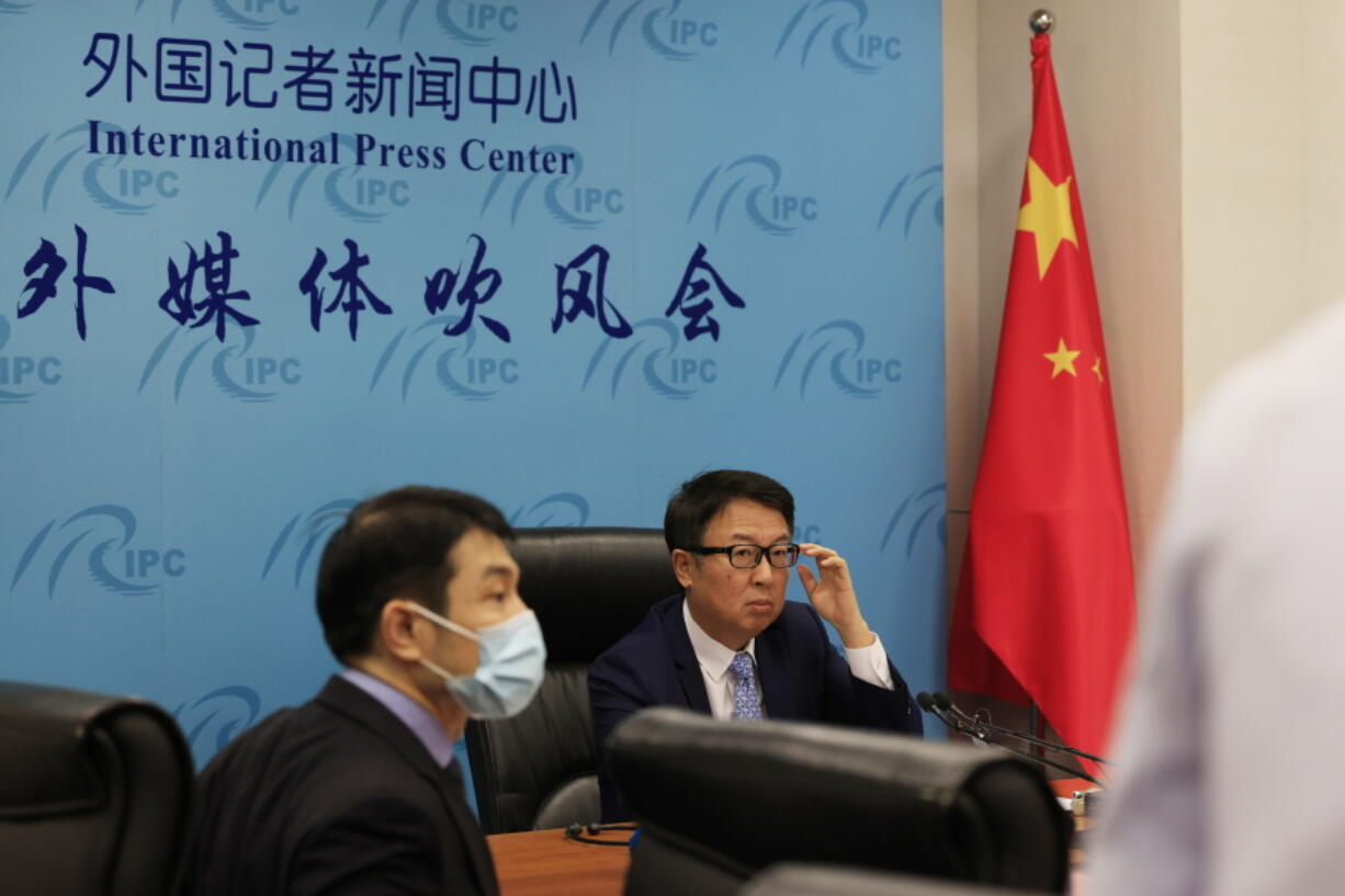 Director of the Chinese Foreign Ministry's Africa Department, Wu Peng, center right, prepares for a briefing in Beijing on Thursday, May 20, 2021.