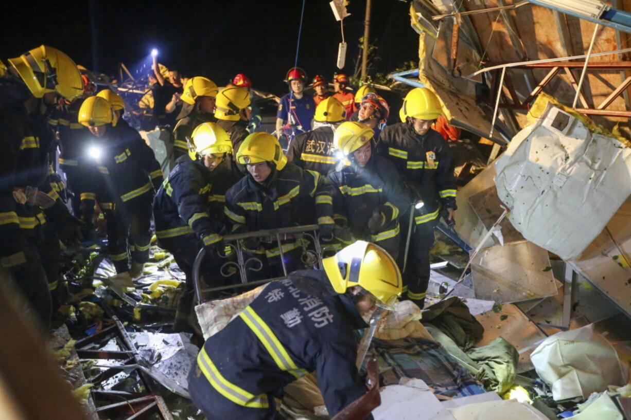 In this photo released by China's Xinhua News Agency, emergency personnel search through the wreckage of buildings destroyed by a reported tornado in Wuhan in central China's Hubei Province, early Saturday, May 15, 2021. Two tornadoes killed several people in central and eastern China and left hundreds of others injured, officials and state media reported Saturday.