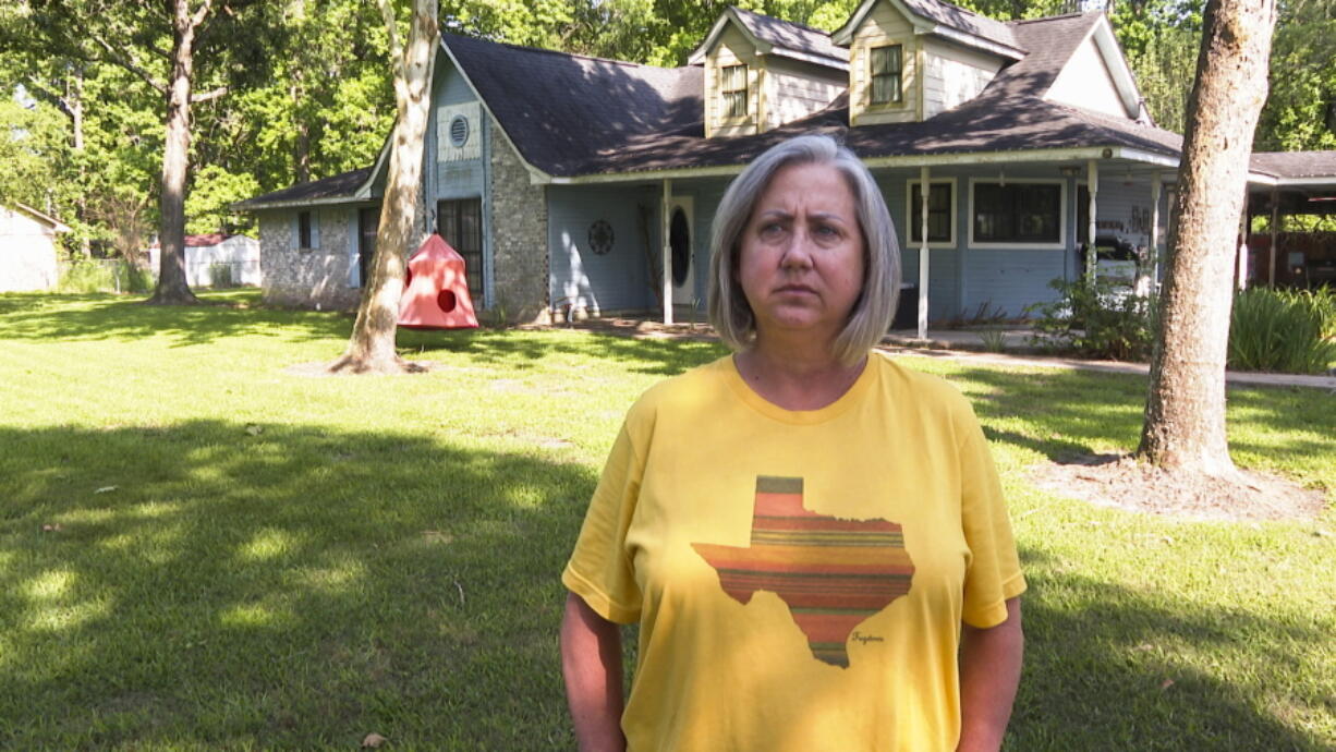 Laurie Fields, who lives in Forest Manor subdivision, speaks during an interview outside her Huffman, Texas home on May 10, 2021. Fields says her home took on feet of water during Hurricane Harvey in 2017 and Tropical Storm Imelda in 2019.  She supports a proposed $1.7 million storm water mitigation project which could help protect her neighborhood from future flooding. (AP Photo/John L.