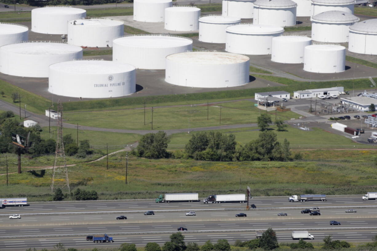 FILE - In this Sept. 8, 2008 file photo traffic on I-95 passes oil storage tanks owned by the Colonial Pipeline Company in Linden, N.J. A major pipeline that transports fuels along the East Coast says it had to stop operations because it was the victim of a cyberattack.