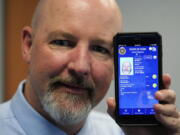 Ryan Williams, with the Utah Drivers License Division, displayes his cell phone with the pilot version of the state's mobile ID on Wednesday, May 5, 2021, in West Valley City, Utah. The card that millions of people use to prove their identity to everyone from police officers to liquor store owners may soon be a thing of the past as a growing number of states develop digital driver's licenses. In Utah, over 100 people have a pilot version of the state's mobile ID, and that number is expected to grow to 10,000 by year's end. Widespread production is expected to begin at the start of 2022.