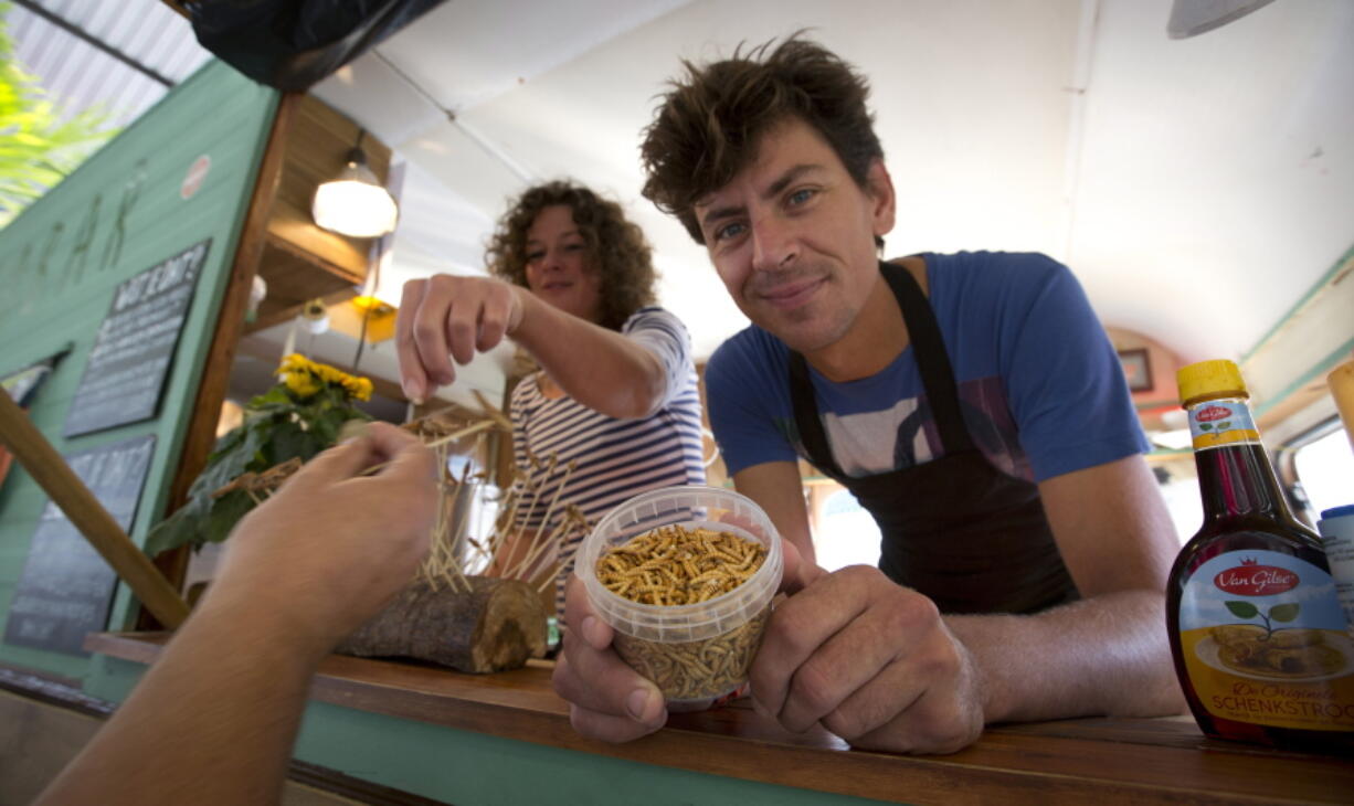 Food truck owner Bart Smit holds a container of yellow mealworms in Antwerp, Belgium, in 2014.