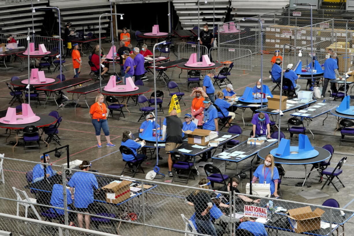 FILE - In this May 6, 2021 file photo, Maricopa County ballots cast in the 2020 general election are examined and recounted by contractors working for Florida-based company, Cyber Ninjas at Veterans Memorial Coliseum in Phoenix. For some conspiracy theorists, the 2020 election still hasn't ended. Trump supporters are pushing to re-examine ballots from November across the country, and finding success in swing states like Arizona and Georgia. Their efforts and sometimes misleading conclusions are being gleefully amplified by the former president.