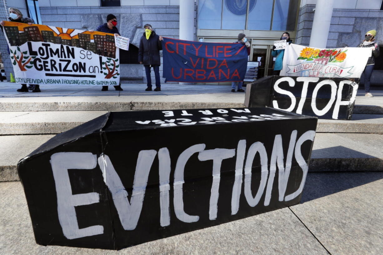 FILE - In this Jan. 13, 2021, file photo, demonstrators hold signs in front of the Edward W. Brooke Courthouse in Boston. A federal judge has ruled, Wednesday, May 5, 2021, that the Centers for Disease Control exceeded its authority when it imposed a federal eviction moratorium to provide protection for renters out of concern that having families lose their homes and move into shelters or share crowded conditions with relatives or friends during the pandemic would further spread the highly contagious virus.