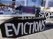 FILE - In this Jan. 13, 2021, file photo, demonstrators hold signs in front of the Edward W. Brooke Courthouse in Boston. A federal judge has ruled, Wednesday, May 5, 2021, that the Centers for Disease Control exceeded its authority when it imposed a federal eviction moratorium to provide protection for renters out of concern that having families lose their homes and move into shelters or share crowded conditions with relatives or friends during the pandemic would further spread the highly contagious virus.