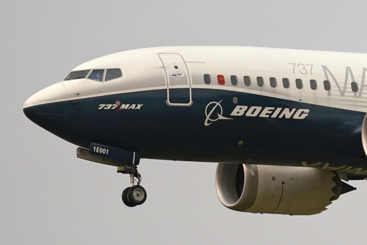 FILE- In this Sept. 30, 2020, file photo, a Boeing 737 Max jet, piloted by Federal Aviation Administration (FAA) chief Steve Dickson, prepares to land at Boeing Field following a test flight in Seattle. Federal regulators have approved a Boeing procedure to fix about 100 jets that have been sitting for a month because of an electrical-grounding issue. The electrical problem was the latest issue affecting Boeing's best-selling 737 Max jet, which was grounded for nearly two years after two deadly crashes. Boeing said Thursday, May 13, 2021 it will help airlines fix the electrical issue on certain Max jets.