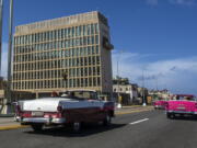 FILE - In this Oct. 3, 2017, file photo, tourists ride classic convertible cars on the Malecon beside the United States Embassy in Havana, Cuba. The Biden administration faces increasing pressure to respond to a sharply growing number of reported injuries suffered by diplomats, intelligence officers and military personnel that some suspect are caused by devices that emit waves of energy that disrupt brain function. The problem has been labeled the "Havana Syndrome," because the first cases affected personnel in 2016 at the U.S. Embassy in Cuba.