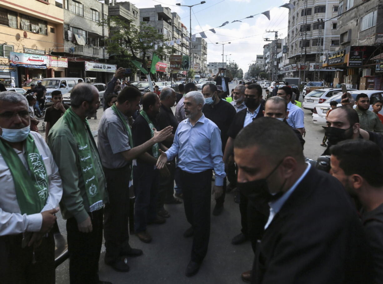 Top Hamas leader in Gaza, Yehiyeh Sinwar, center, pays his respects at a house of mourning for a Hamas commander killed in the war, in Gaza City, Saturday, May 22, 2021. Sinwar, made his first public appearance since the militant group's war with Israel erupted earlier this month.