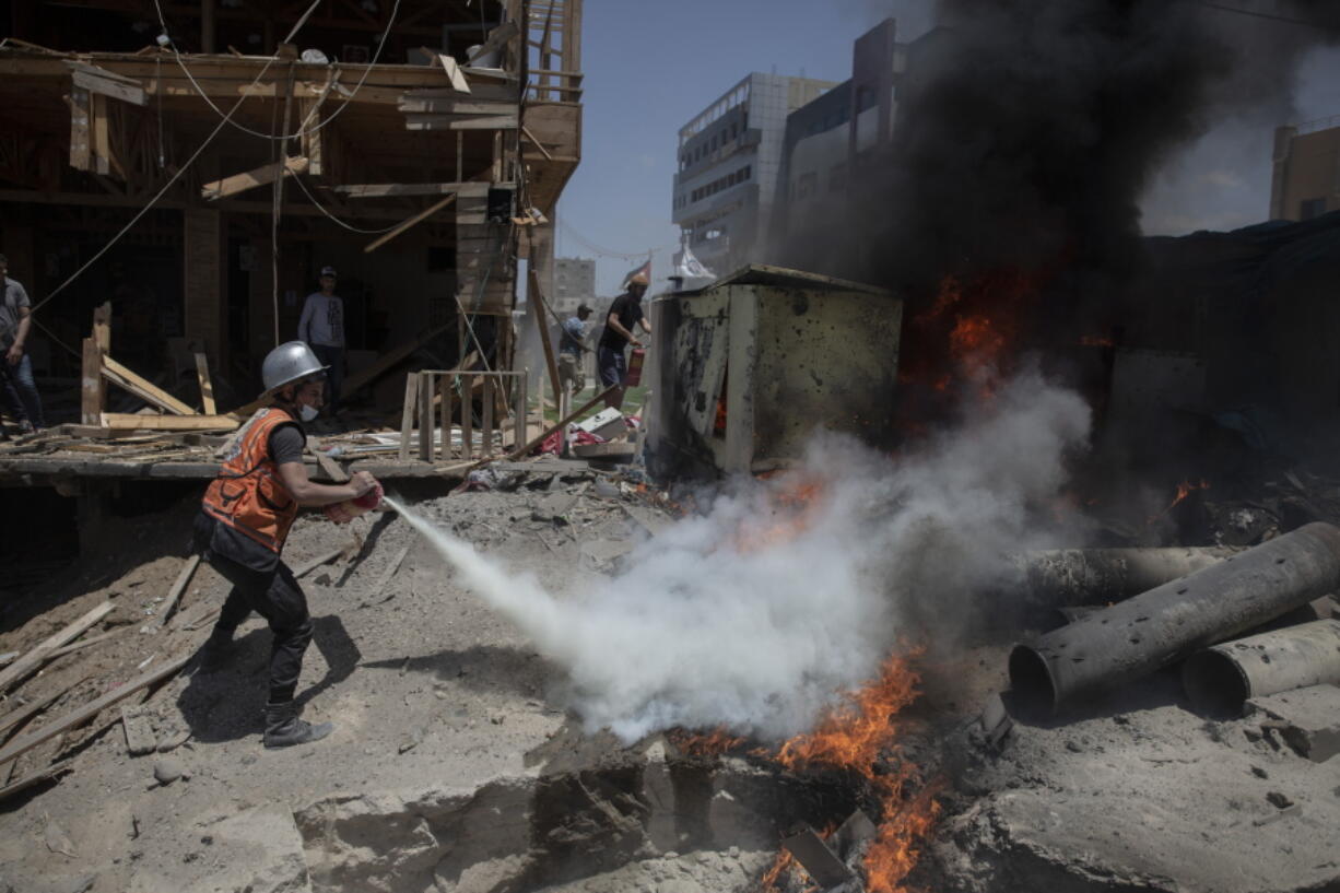 A Palestinian firefighter extinguishes a fire from a beachside cafe after it was hit by an Israeli airstrike, in Gaza City, Monday, May 17, 2021.