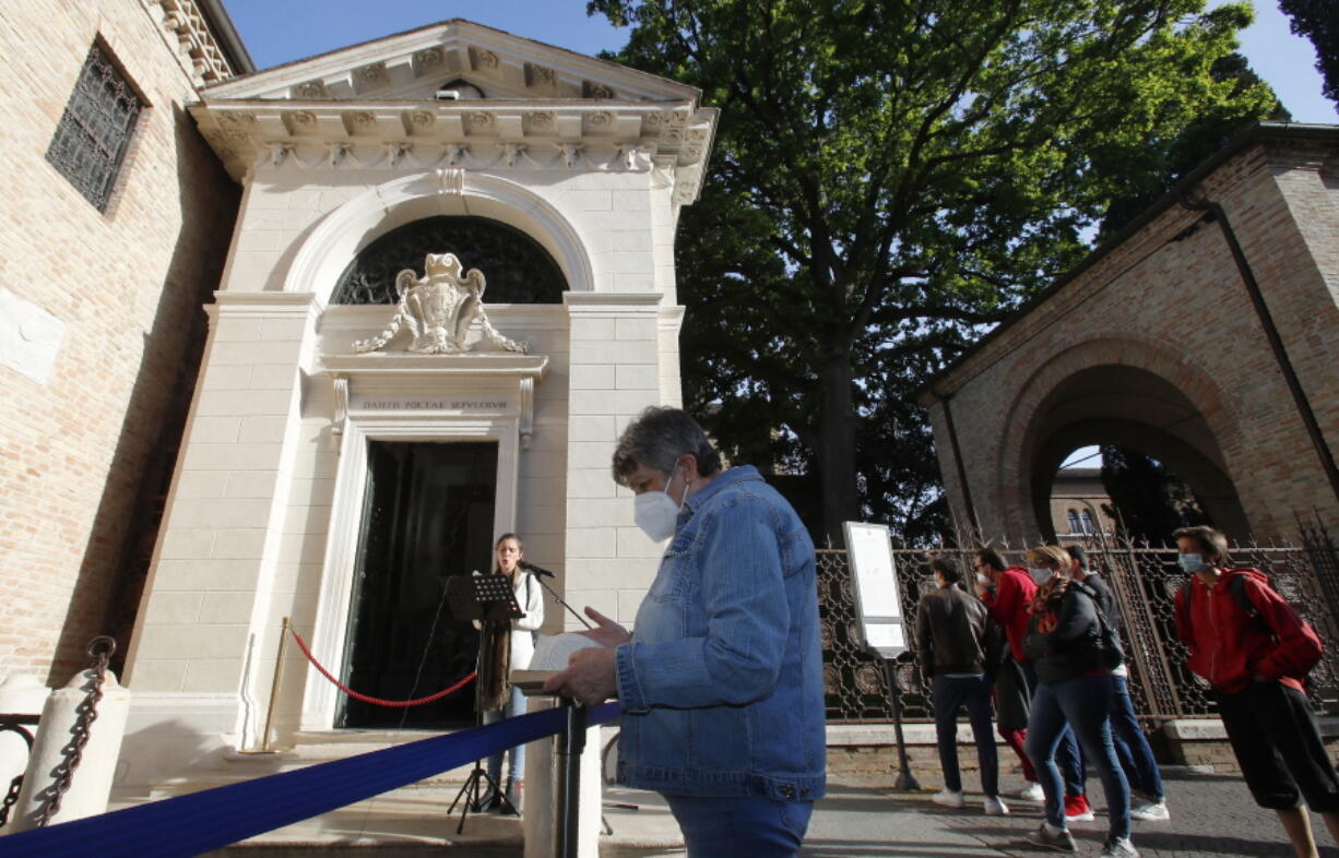 Ravenna resident Giuliana Turati, center, holds a copy of poet Dante Alighieri's "Divina Commedia" as she listens to a reading by volunteer Carlotta Zangolli in front of Dante's tomb May 8 in Ravenna, Italy.