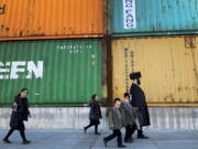 Members of the Orthodox Jewish community walk past shipping containers in the South Williamsburg neighborhood of Brooklyn, New York, in March.