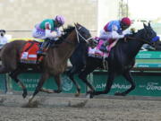 John Velazquez, right, rides Medina Spirit ahead of Florent Geroux aboard Mandaloun to win the 147th running of the Kentucky Derby at Churchill Downs, Saturday, May 1, 2021, in Louisville, Ky.