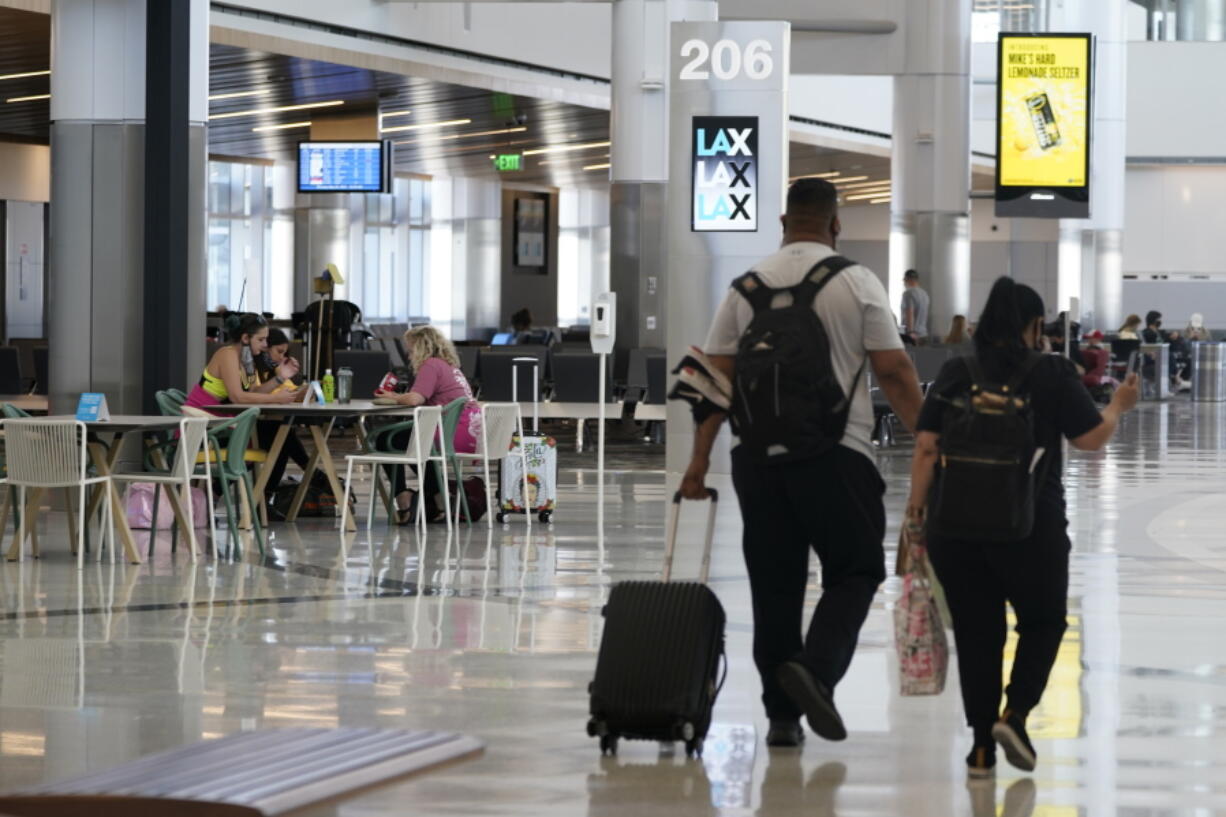 Passengers wait for their flights inside the new West Gates at Tom Bradley International Terminal at Los Angeles International Airport Monday, May 24, 2021, in Los Angeles.