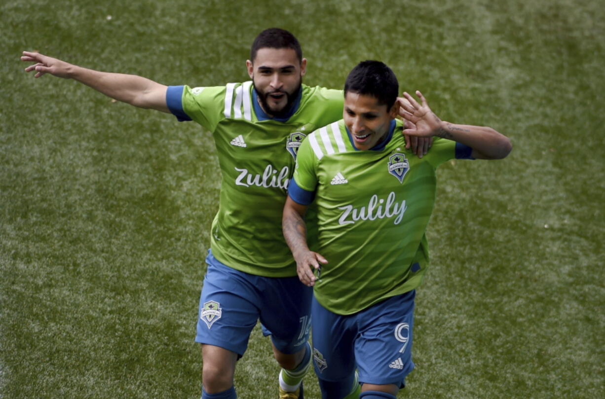 Seattle Sounders forward Raul Ruidiaz, right, celebrates with midfielder Alex Roldan, left, after scoring during second half of an MLS soccer match against the Portland Timbers in Portland, Ore., Sunday, May 9, 2021.