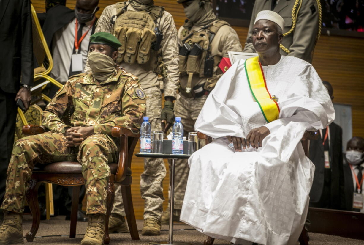 FILE- In this Friday, Sept. 25, 2020 file photo, retired Col. Maj. Bah N'Daw, right, is sworn into the office of transitional president, and Col. Assimi Goita, left, head of the junta that staged the Aug. 18 2020 coup, is sworn into the office of transitional vice president, at a ceremony in the capital Bamako, Mali.