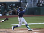 Seattle Mariners' Kyle Lewis hits a two-run home run against the Oakland Athletics during the third inning of a baseball game in Oakland, Calif., Monday, May 24, 2021.