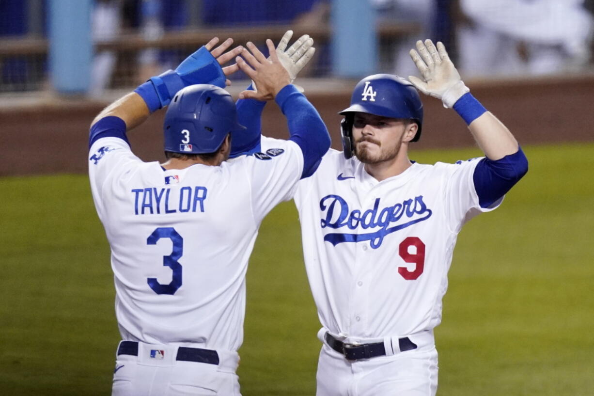 Los Angeles Dodgers' Gavin Lux, right, is congratulated by Chris Taylor after hitting a three-run home run during the eighth inning of an interleague baseball game against the Seattle Mariners Tuesday, May 11, 2021, in Los Angeles. (AP Photo/Mark J.