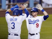 Los Angeles Dodgers' Gavin Lux, right, is congratulated by Chris Taylor after hitting a three-run home run during the eighth inning of an interleague baseball game against the Seattle Mariners Tuesday, May 11, 2021, in Los Angeles. (AP Photo/Mark J.