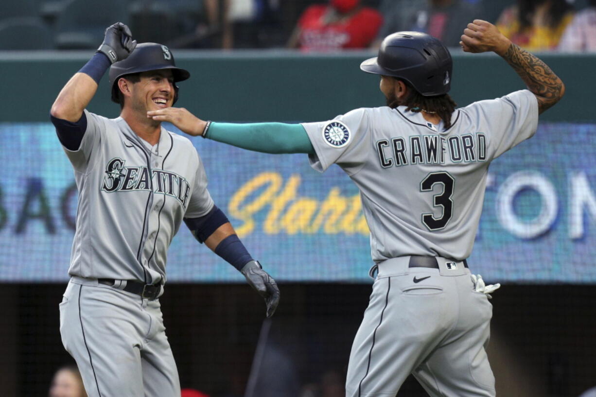 Seattle Mariners' Dylan Moore (25) celebrates his two-run home run with J.P. Crawford (3) during the second inning against the Texas Rangers in a baseball game Friday, May 7, 2021, in Arlington, Texas. (AP Photo/Richard W.