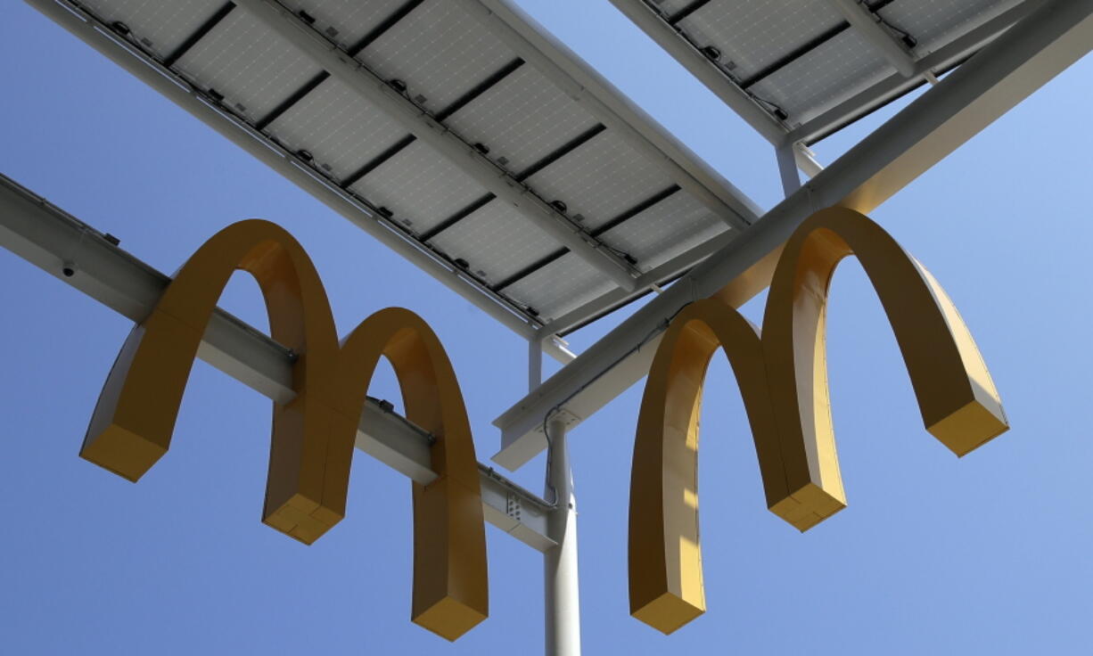 FILE- This Aug. 8, 2018, photo shows logos of McDonald's Chicago flagship restaurant. McDonald's is raising pay at 650 company-owned stores in the U.S. as part of its push to hire thousands of new workers in a tight labor market. The fast food giant is the latest restaurant chain to announce pay raises. (AP Photo/Nam Y.