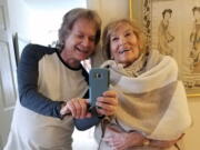 Leland Stein, left, takes a photo with his mother Sondra Green in her apartment in New York in  2018.