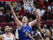 Denver Nuggets center Nikola Jokic, center, shoots over Portland Trail Blazers guard CJ McCollum, right, forward Robert Covington, second from right, and center Enes Kanter, left, during the first half of Game 3 of an NBA basketball first-round playoff series Thursday, May 27, 2021, in Portland, Ore.