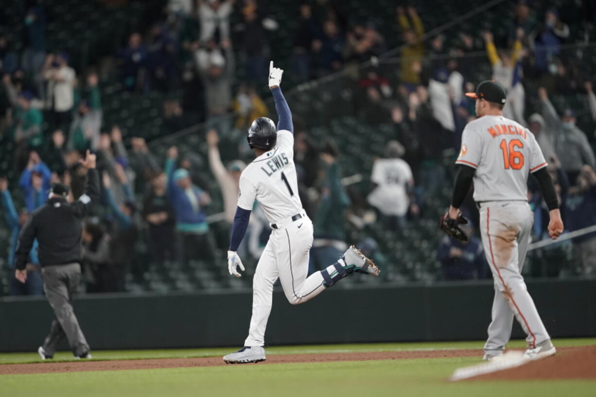 Seattle Mariners' Kyle Lewis celebrates after he hit a three-run home run as Baltimore Orioles first baseman Trey Mancini looks on during the eighth inning of a baseball game, Tuesday, May 4, 2021, in Seattle. (AP Photo/Ted S.