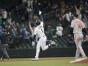 Seattle Mariners' Kyle Lewis celebrates after he hit a three-run home run as Baltimore Orioles first baseman Trey Mancini looks on during the eighth inning of a baseball game, Tuesday, May 4, 2021, in Seattle. (AP Photo/Ted S.