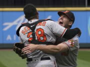 Baltimore Orioles starting pitcher John Means, right, hugs catcher Pedro Severino after Means threw a no-hitter in the team's baseball game against the Seattle Mariners, Wednesday, May 5, 2021, in Seattle. The Orioles won 6-0. (AP Photo/Ted S.