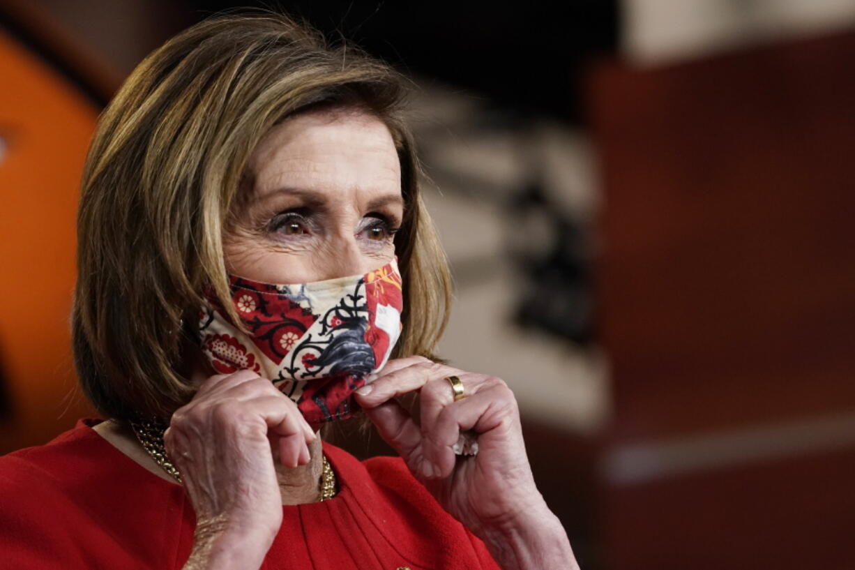 House Speaker Nancy Pelosi puts her mask back on after a news conference May 13.