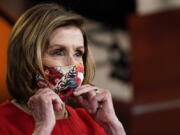 House Speaker Nancy Pelosi puts her mask back on after a news conference May 13.