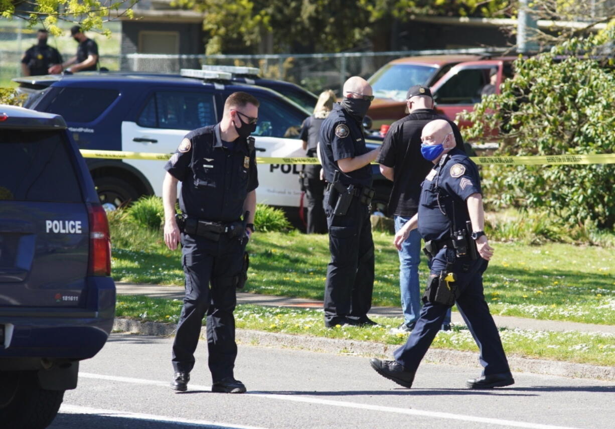 FILE - In this Friday, April 16, 2021, file photo, law enforcement personnel work at the scene following a police-involved shooting of a man at Lents Park, in Portland, Ore. Police fatally shot a man in the city park Friday, April 30, 2021 after responding to reports of a person with a gun. Unlike shootings involving police around the country there was no body camera footage of this encounter. Portland, which has become the epicenter of racial justice protests, is one of the few major U.S. cities where police do not have body cameras.