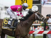 Flavien Prat atop Rombauer reacts as he crosses the finish line to win the Preakness Stakes horse race at Pimlico Race Course, Saturday, May 15, 2021, in Baltimore.