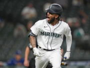 Seattle Mariners' J.P. Crawford turns toward the team dugout and lets out a yell as he begins to round the bases on his solo home run against the Texas Rangers during the seventh inning of a baseball game Saturday, May 29, 2021, in Seattle.