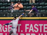 Texas Rangers right fielder Joey Gallo and a fan compete for the home run ball of Seattle Mariners' Kyle Seager in the fifth inning of a baseball game Sunday, May 30, 2021, in Seattle.