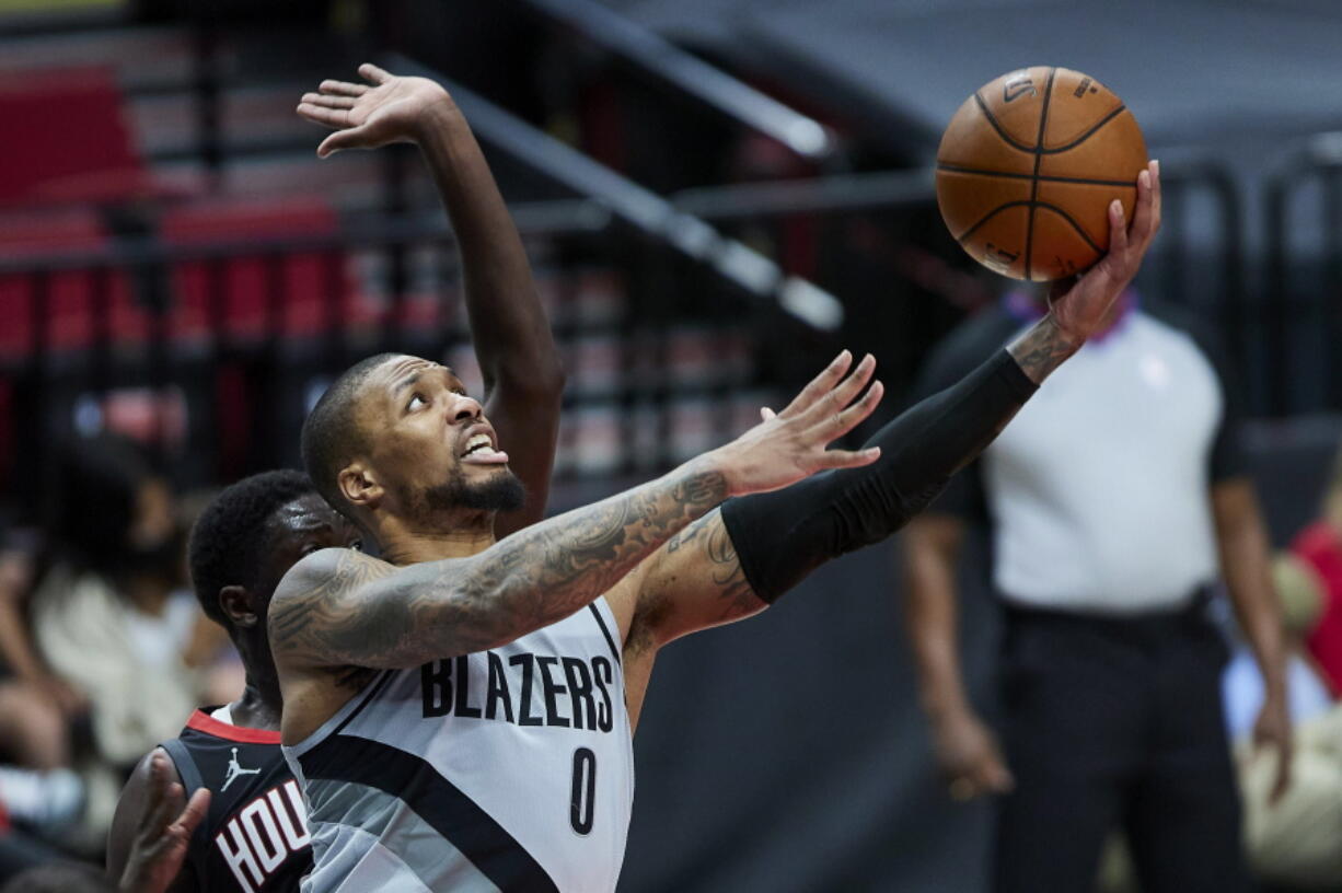 Portland Trail Blazers guard Damian Lillard (0) shoots in front of Houston Rockets forward Khyri Thomas during the second half on Monday in Portland.