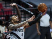 Portland Trail Blazers guard Damian Lillard (0) shoots in front of Houston Rockets forward Khyri Thomas during the second half on Monday in Portland.