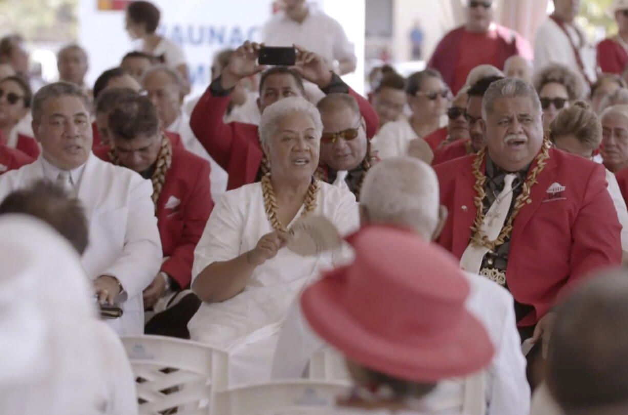 In this image made from video, Prime Minister-elect Fiame Naomi Mata'afa, center with fan, dits with her supporters Monday, May 24, 2021, in Apia, Samoa. Samoa was plunged into a constitutional crisis Monday when Mata'afa, who won an election last month, was locked out of Parliament and the previous leader claimed he remained in charge.