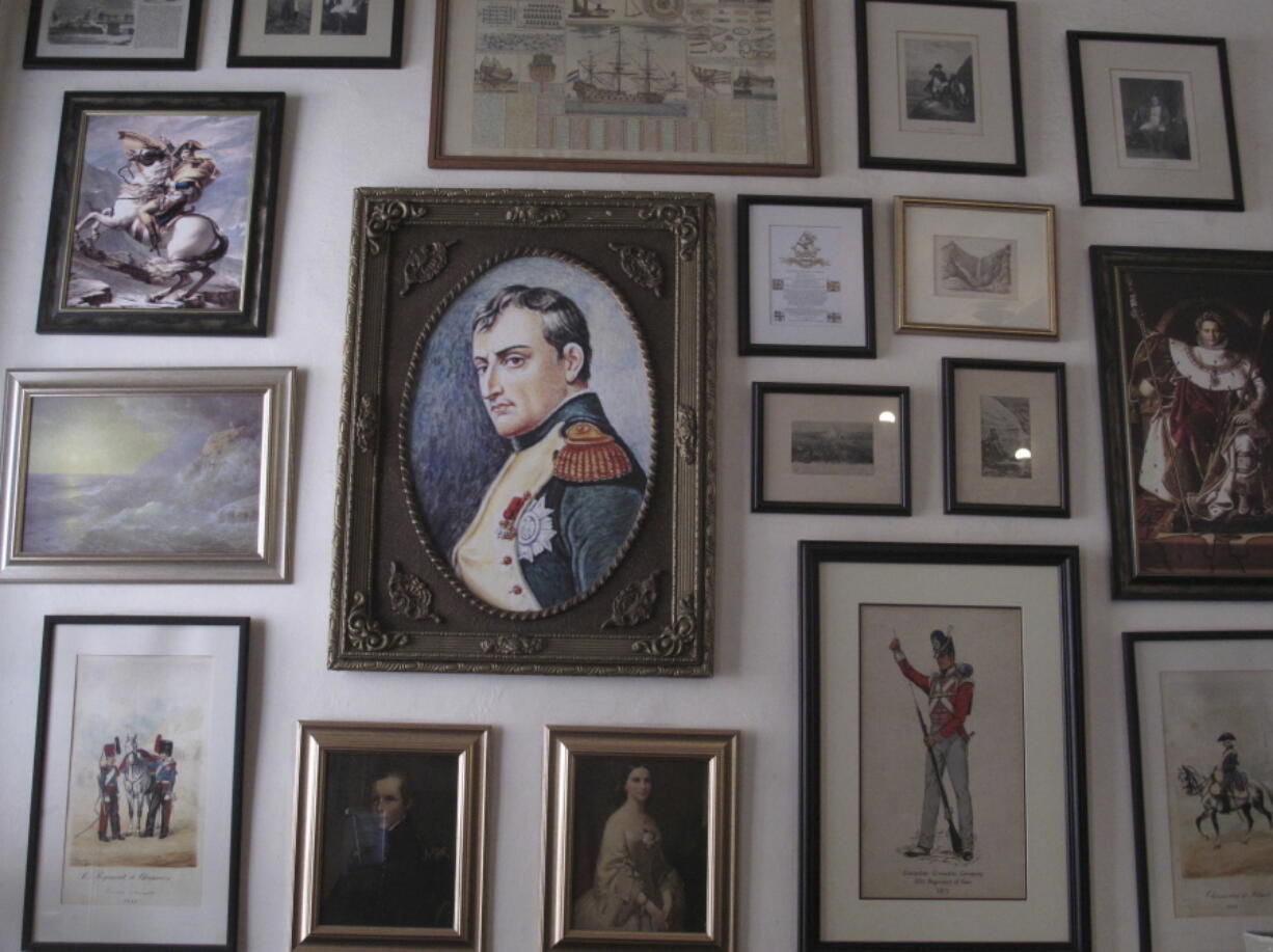 FILE - In this Oct. 15, 2017, file photo, several images of Napoleon Bonaparte are shown in this collection of framed pictures on a wall in the Consulate hotel in Jamestown on St. Helena island in the Atlantic Ocean. Commemorations of the May 5, 1821 death of Napoleon are going ahead on St. Helena, the remote South Atlantic island where the deposed French emperor died in exile. But they are not happening with an influx of international visitors that was expected before COVID-19 swept across the world. While the volcanic island has not had any confirmed COVID-19 cases, reaching it got even harder because of travel restrictions during the pandemic.