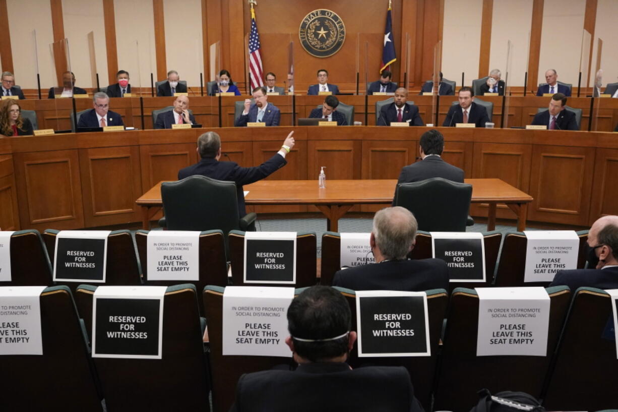 FILE - In this Feb. 25, 2021 file photo, Curtis Morgan, the CEO of Vistra Corp., at table left, testifies as the Committees on State Affairs and Energy Resources holds a joint public hearing to consider the factors that led to statewide electrical blackouts, in Austin, Texas. Only days remain for Texas lawmakers to make good on promised overhauls following one of the largest power outages in U.S. history, when more than 4 million customers lost heat after an artic blast buckled the state's electric grid.