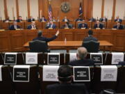 FILE - In this Feb. 25, 2021 file photo, Curtis Morgan, the CEO of Vistra Corp., at table left, testifies as the Committees on State Affairs and Energy Resources holds a joint public hearing to consider the factors that led to statewide electrical blackouts, in Austin, Texas. Only days remain for Texas lawmakers to make good on promised overhauls following one of the largest power outages in U.S. history, when more than 4 million customers lost heat after an artic blast buckled the state's electric grid.