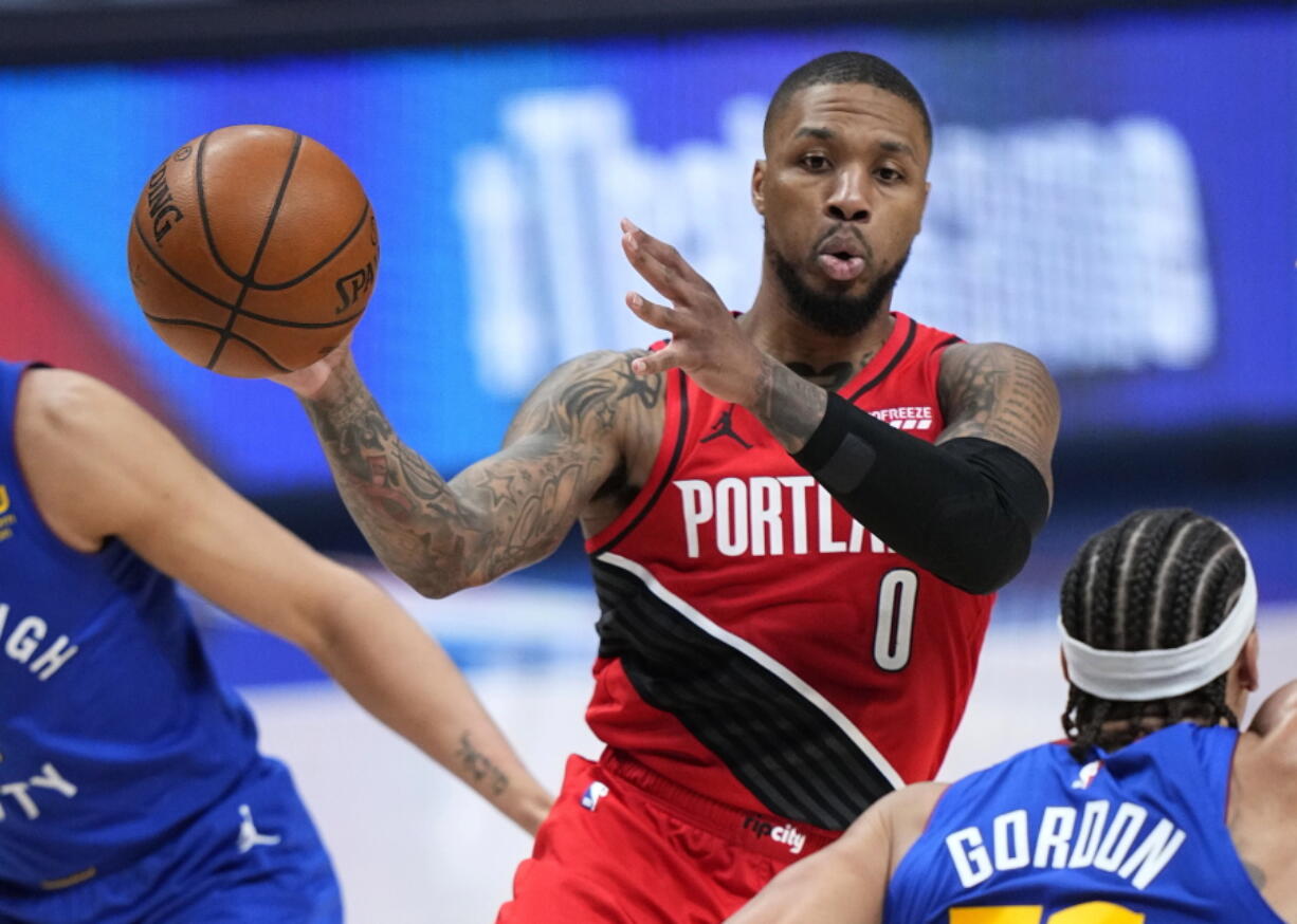 Portland Trail Blazers guard Damian Lillard (0) passes the ball against the Denver Nuggets during the second half of Game 1 of a first-round NBA basketball playoff series Saturday, May 22, 2021, in Denver.