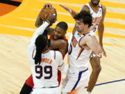 Portland Trail Blazers guard Damian Lillard is pressured by Phoenix Suns forward Jae Crowder (99) and forward Dario Saric, right, during the second half of an NBA basketball game, Thursday, May 13, 2021, in Phoenix.