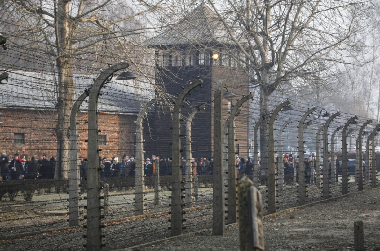 FILE- In this file photo taken Jan. 27, 2020, people are seen arriving at the site of the Auschwitz-Birkenau Nazi German death camp, where more than 1.1 million were murdered, in Oswiecim, Poland, for observances marking 75 years since the camp's liberation by the Soviet army. Needham, Massachusetts-based TripAdvisor on Thursday, May 6, 2021, faced criticism from the camp's museum and memorial after an author posted an inappropriate review of the museum on the TripAdvisor website, stating the reviewer visited to "test the chamber". The company originally declined to remove the message.