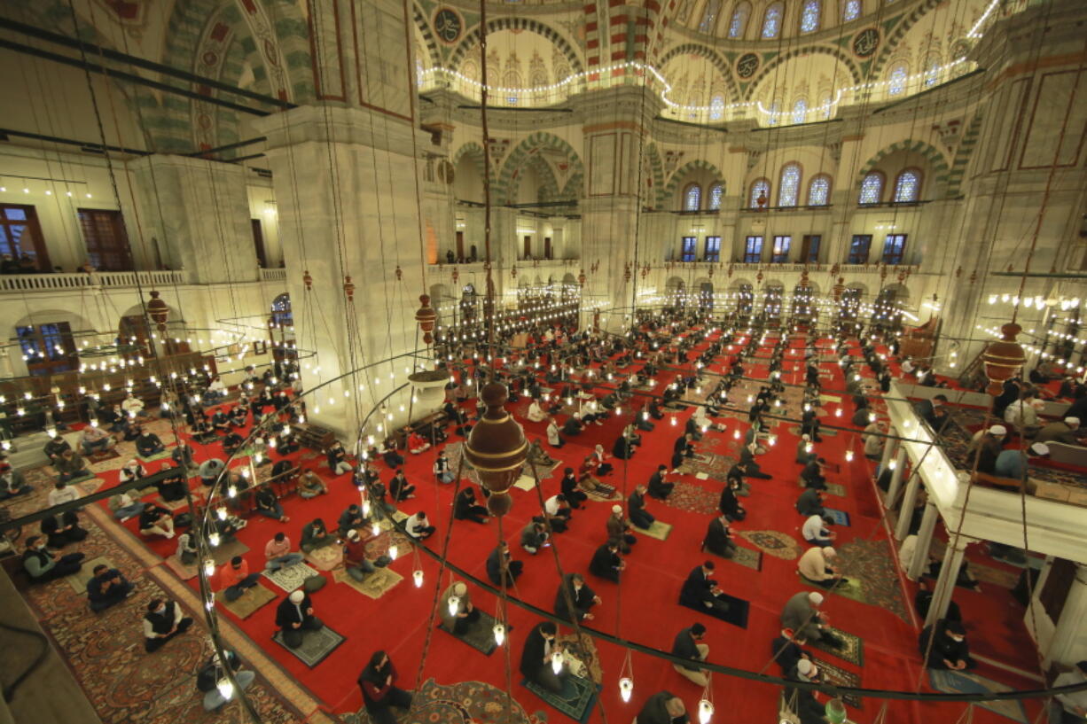 Muslims offer prayers during the first day of Eid al-Fitr, which marks the end of the holy month of Ramadan at Fatih Mosque in Istanbul, Thursday, May 13, 2021. Hundreds of Muslims attended dawn Eid al-Fitr prayers Thursday marking the end of the month of prayer and fasting for Muslims around the world, a usually joyous three-day celebration that has been significantly toned down as coronavirus cases soar.