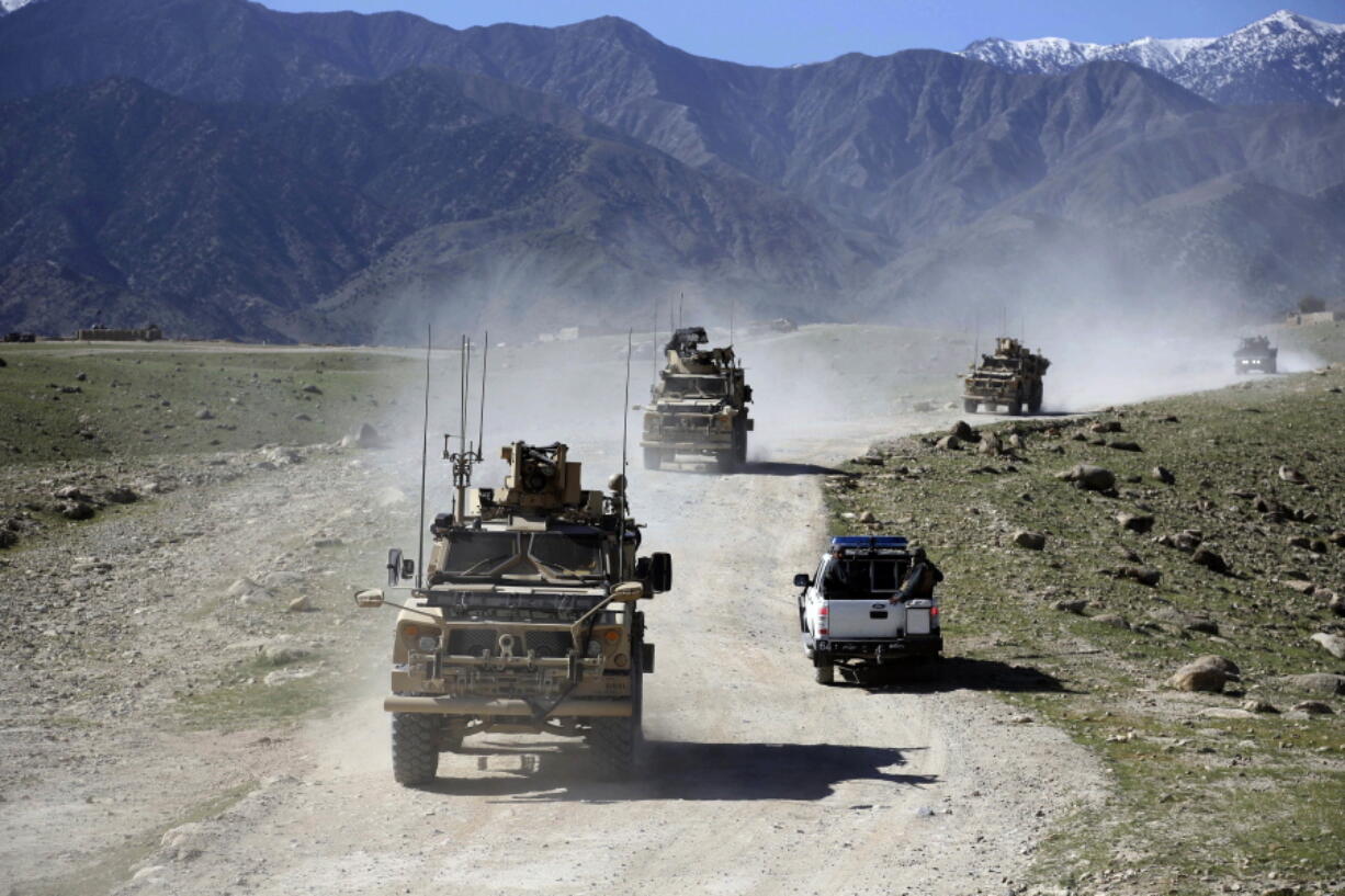 FILE - In this April 2014 file photo, U.S. forces and Afghan commando patrol Pandola village near the site of a U.S. bombing in the Achin district of Jalalabad, east of Kabul, Afghanistan. When he pulled the plug on the American war in Afghanistan, President Joe Biden said the reasons for staying, 10 years after the death of al-Qaida leader Osama bin Laden, had become "increasingly unclear." Now that the final withdrawal is under way, questions about clarity have shifted to Biden's post-withdrawal plan.