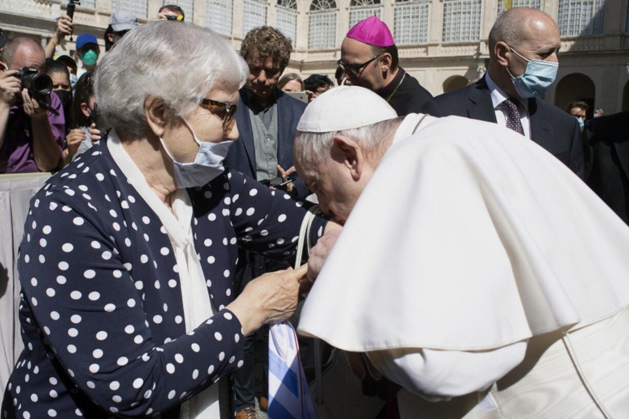 Pope Francis leans and kiss a tattoo on the arm of Holocaust survivor Lidia Maksymowicz, a Polish citizen who was deported to Auschwitz from her native Belarus, during his weekly general audience at the Vatican, Wednesday, May 26, 2021. Pope Francis has kissed the tattoo of an Auschwitz survivor during a general audience on Wednesday. Lidia Maksymowicz, a Polish citizen who was deported to Auschwitz from her native Belarus, showed the pope the number tattooed on her arm by the Nazis, and Francis leaned over and kissed it Wednesday. Maksymowicz told Vatican News that she did not exchange words with the pope.