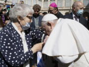 Pope Francis leans and kiss a tattoo on the arm of Holocaust survivor Lidia Maksymowicz, a Polish citizen who was deported to Auschwitz from her native Belarus, during his weekly general audience at the Vatican, Wednesday, May 26, 2021. Pope Francis has kissed the tattoo of an Auschwitz survivor during a general audience on Wednesday. Lidia Maksymowicz, a Polish citizen who was deported to Auschwitz from her native Belarus, showed the pope the number tattooed on her arm by the Nazis, and Francis leaned over and kissed it Wednesday. Maksymowicz told Vatican News that she did not exchange words with the pope.