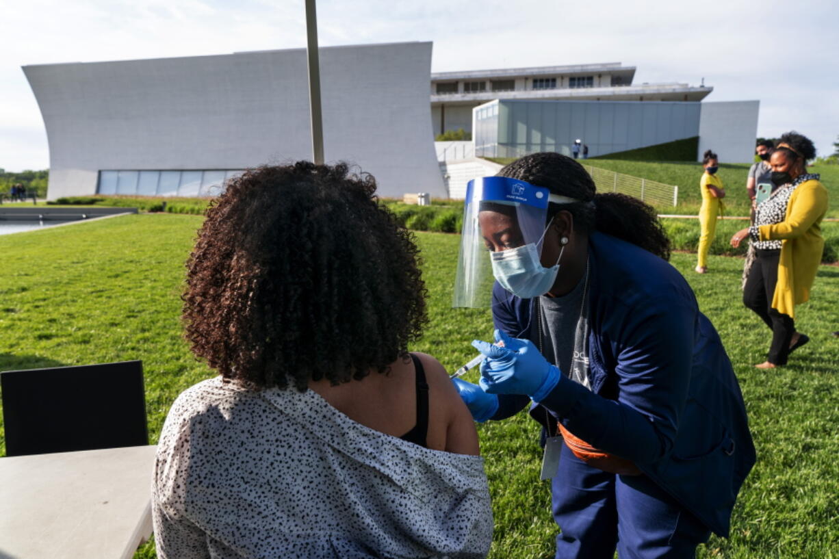 FILE - In this May 6, 2021, file photo, Kendria Brown, a nurse with DC health, vaccinates a woman with the Johnson & Johnson COVID-19 vaccine at The REACH at the Kennedy Center in Washington. From South Carolina to Washington, states are requesting the Biden administration send them only a fraction of what's been allocated to them. The turned-down vaccines amount to hundreds of thousands of doses this week alone, providing a stark illustration of the problem of vaccine hesitancy in the U.S.