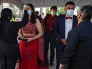 Grace Gardens Event Center employees check temperatures of young people attending prom at the Grace Gardens Event Center in El Paso, Texas on Friday, May 7, 2021. Around 2,000 attended the outdoor event at the private venue after local school districts announced they would not host proms this year. Tickets cost $45.